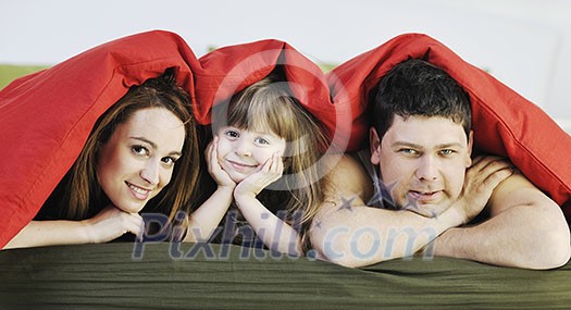 happy young family relaxing in bed happy young family relaxing in bed