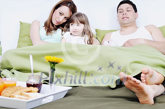 happy young family eat breakfast in bed at morning 