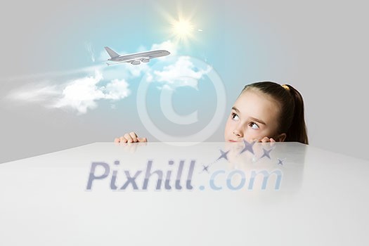 Little adorable girl looking at flying airplane
