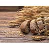 Bread and wheat on wooden table, shallow DOF, raw image