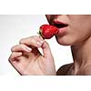 Young woman biting strawberry isolated on white
