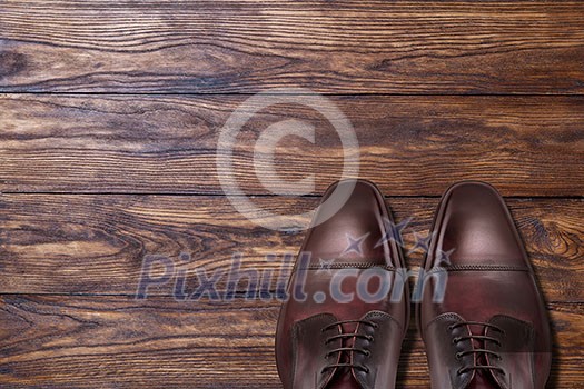 Classic male brown leather shoes on wooden background