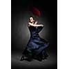 young woman dancing flamenco on black