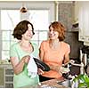 Mother and daughter doing dishes in kitchen at home