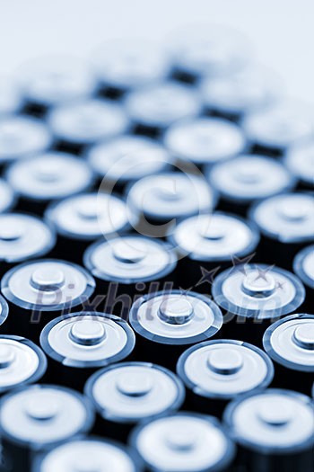 Tops of many AA batteries in closeup