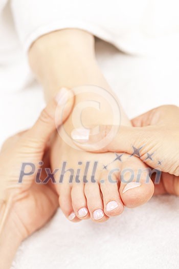 Female hands giving massage to soft bare foot Female hands giving massage to soft bare foot