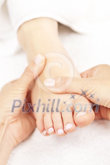 Female hands giving massage to soft bare foot