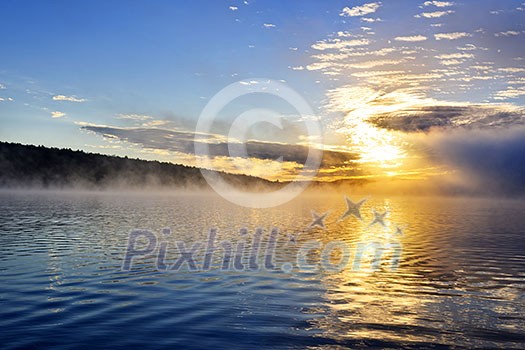 Sun rising over foggy lake in Algonquin Park, Canada Sun rising over foggy lake in Algonquin Park, Canada
