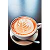 Cup of latte coffee with leaf shape art on foam