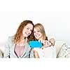 Two smiling women using cellular mobile phone to take a picture
