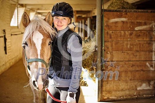 Portrait of teenage girl with horse in stable Portrait of teenage girl with horse in stable
