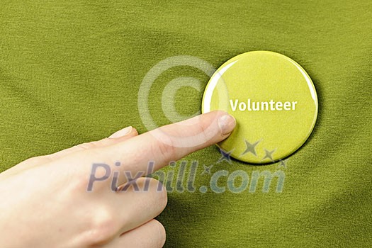 Finger pointing to green round volunteer button Finger pointing to green round volunteer button