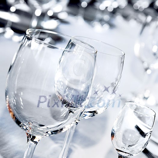 Three glass goblets on white table Three glass goblets on white table