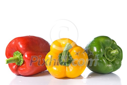 red, yellow and green pepper with water drops isolated on white