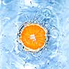 Fresh orange dropped into water with bubbles isolated on white