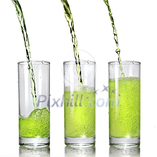 green juice pouring into glass isolated on white green juice pouring into glass isolated on white