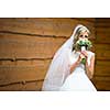 Portrait of a gorgeous young bride on her wedding day - smelling the flowers in her bouquet, enjoying the big day, feeling happy