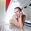 Pretty young woman tanning her skin in a modern solarium