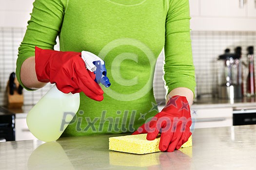 Girl cleaning kitchen  with sponge and rubber gloves