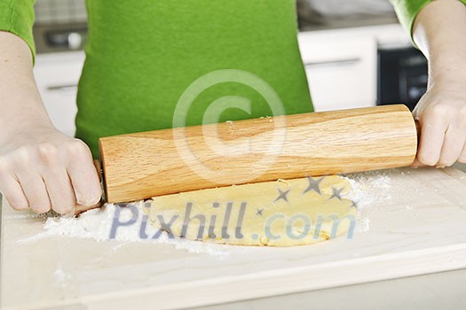 Spreading out cookie dough with wooden rolling pin