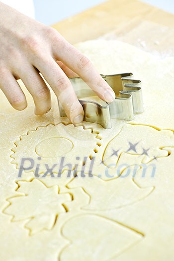 Cutting cookie shapes in rolled dough with cutter