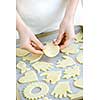 Chef placing cutout cookie dough shapes on tray for baking