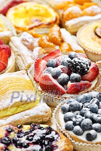 Background of assorted fresh sweet tarts and pastries