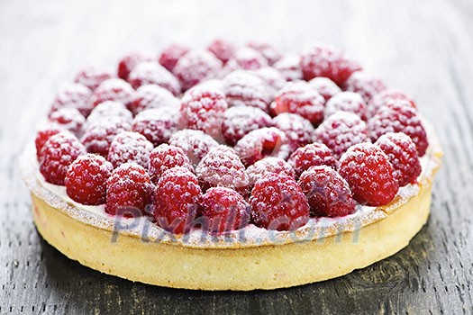 Fresh dessert fruit tart covered in raspberries Fresh dessert fruit tart covered in raspberries