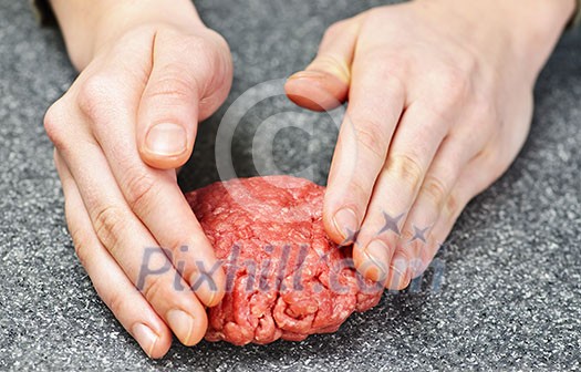 Chef making hamburger patty in kitchen with ground beef