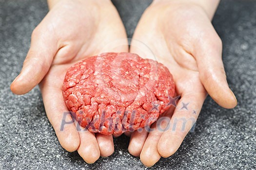 Chef making hamburger patty in kitchen with ground beef