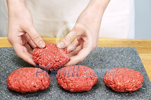 Chef making hamburger patties in kitchen with ground beef Chef making hamburger patties in kitchen with ground beef