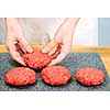 Chef making hamburger patties in kitchen with ground beef