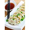 Plate of steamed dumplings with soy sauce and chopsticks