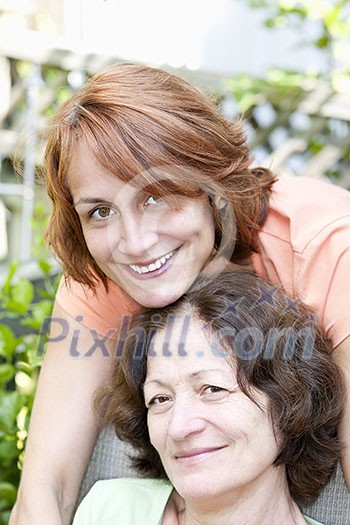 Family portrait of smiling mature mother and daughter
