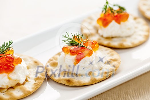 Closeup of caviar and cream cheese appetizer on crackers