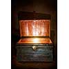 Antique wooden chest with open lid and light inside
