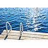 Dock and ladder on calm summer lake with sparkling water in Ontario Canada