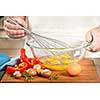 Closeup on man's hands whisking eggs in bowl for cooking omelet with vegetables
