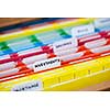 Open file folder drawer with many multicolored files containing personal finance documents
