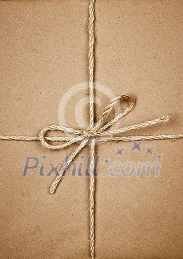 Gift package wrapped in brown paper tied with twine closeup