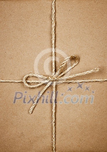 Gift package wrapped in brown paper tied with twine closeup Gift package wrapped in brown paper tied with twine closeup