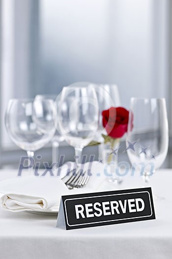 Reserved romantic table setting with roses plates and cutlery Reserved romantic table setting with roses plates and cutlery