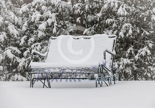 Metal bench covered with snow in winter park Metal bench covered with snow in winter park