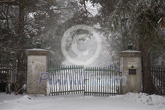 Spooky old broken gate on driveway in winter Spooky old broken gate on driveway in winter