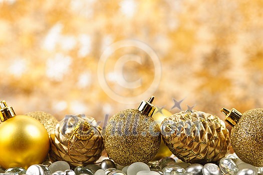 Golden Christmas background with ornaments and pine cones