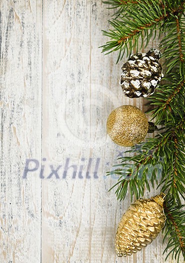 Christmas golden balls and pine cone on spruce branch with wooden background Christmas golden balls and pine cone on spruce branch with wooden background
