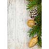 Christmas golden balls and pine cone on spruce branch with wooden background