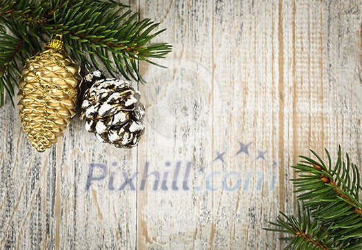 Christmas golden balls and pine cone on spruce branch with wooden background Christmas golden balls and pine cone on spruce branch with wooden background