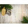 Christmas golden balls and pine cone on spruce branch with wooden background