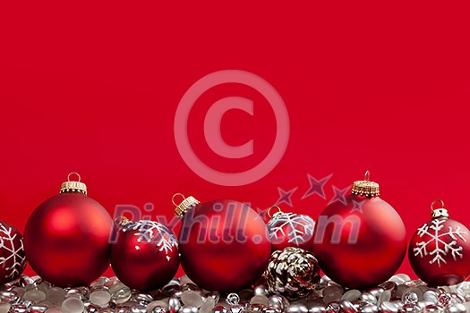 Red and silver Christmas decorations on crimson background